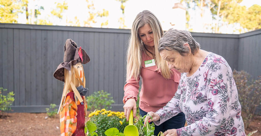 Atria employee with resident gardening